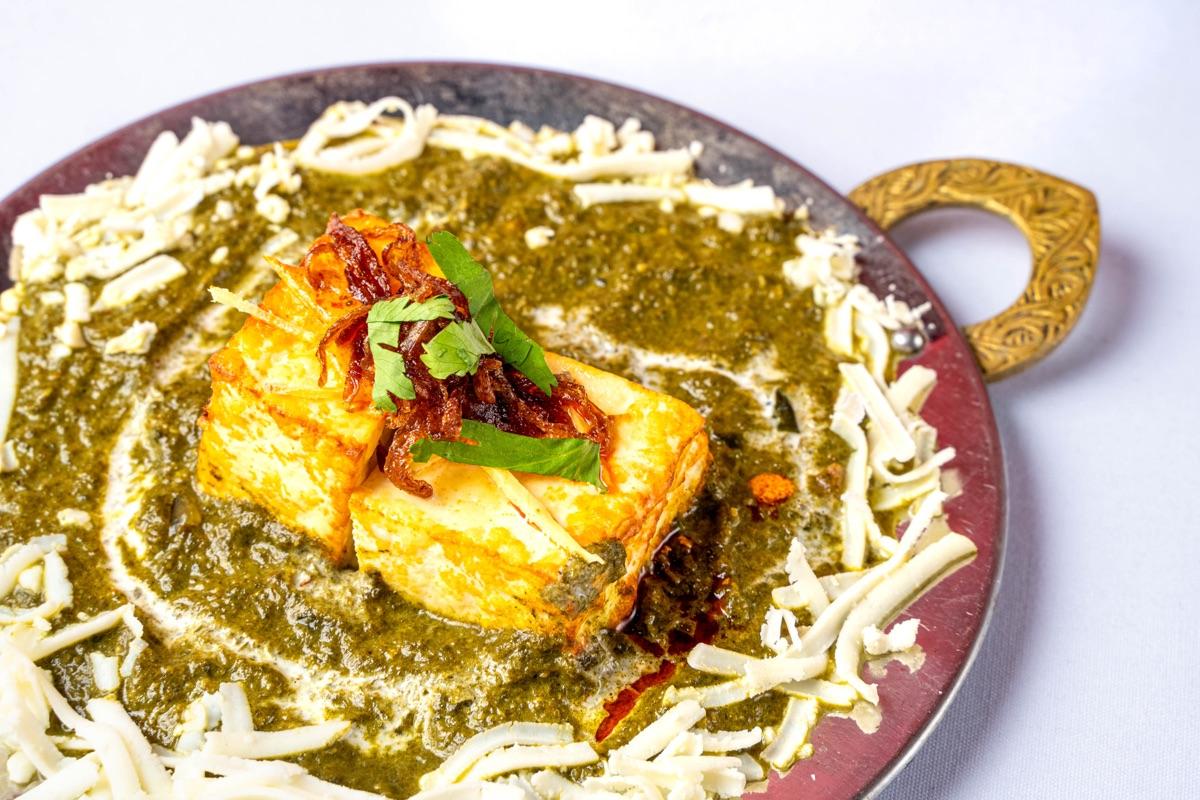 Palak paneer — paneer cubes on a spiced spinach gravy topped with fried onions